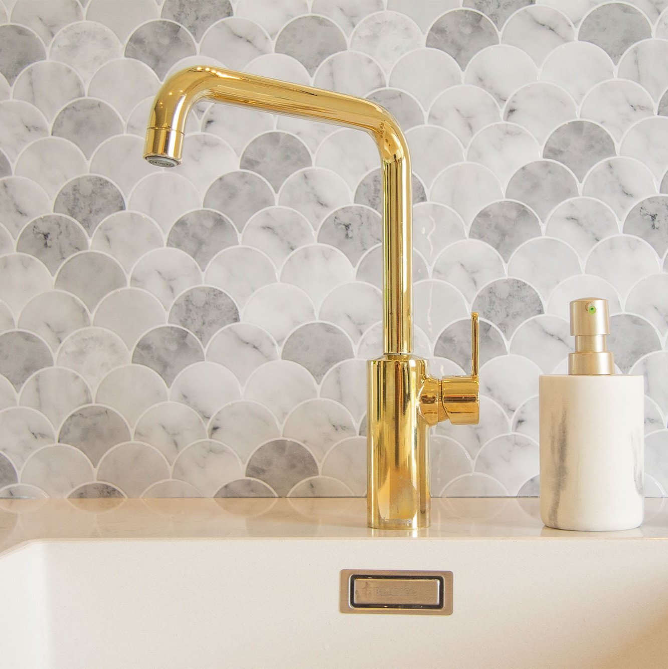 Marmorlignende peel and stick flise (marble shell) fra stickoramic i køkken med hvid håndvask.