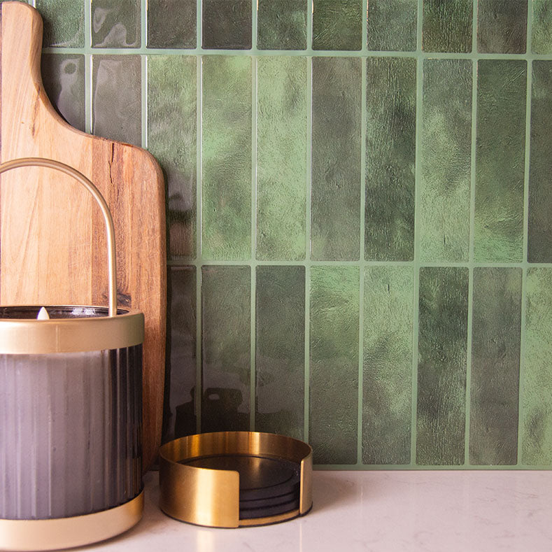 Grønne fliseklistermærker (forest flair) brugt som backsplash i køkken.