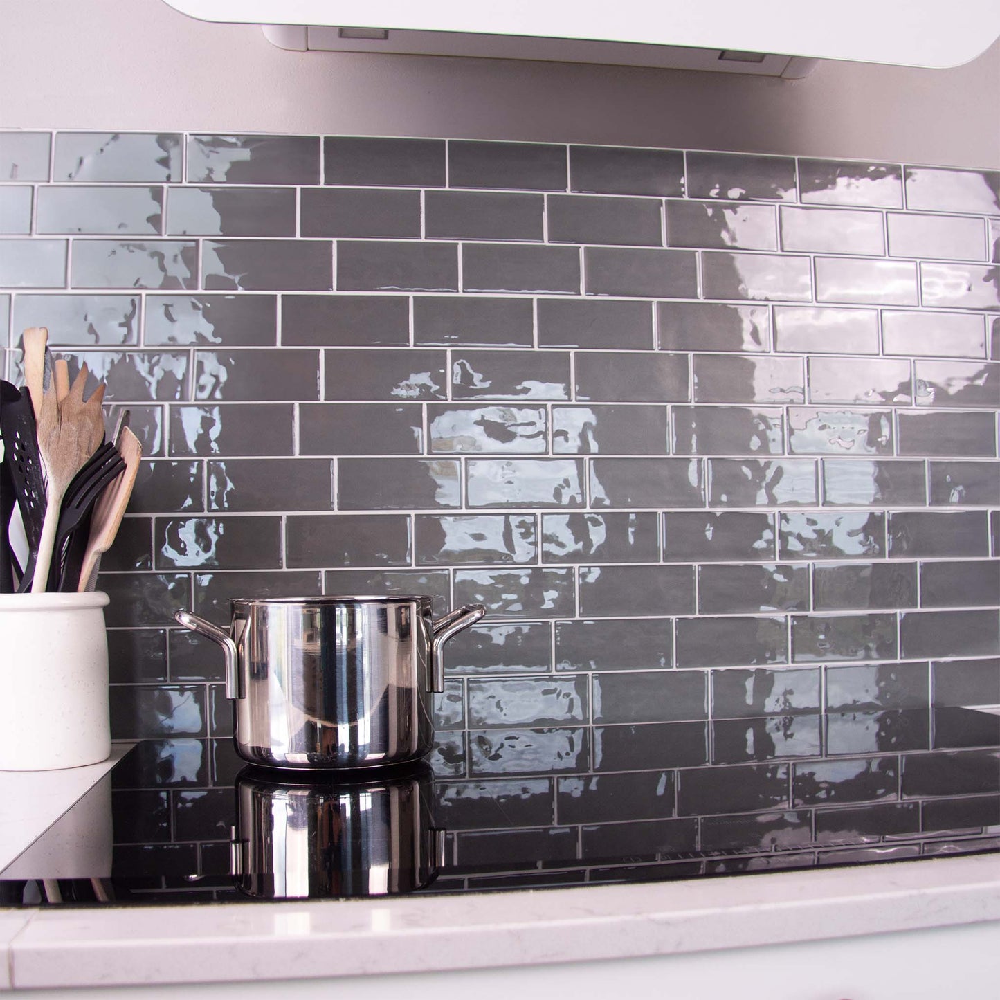Grå fliseklistermærker i metro mønster i køkken som backsplash ved komfur.