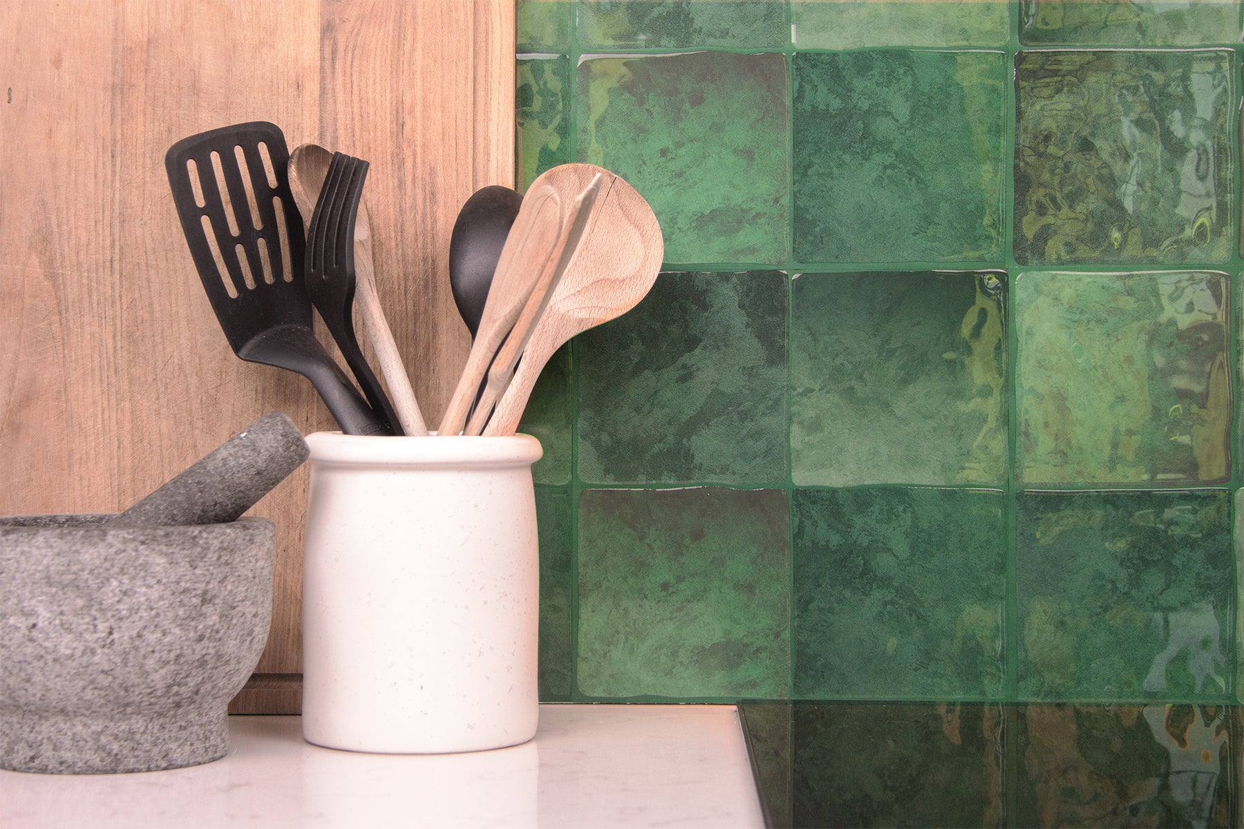 Grønt fliseklistermærke i kvadratisk mønster (mystic moss) i køkken med lys bordplade.