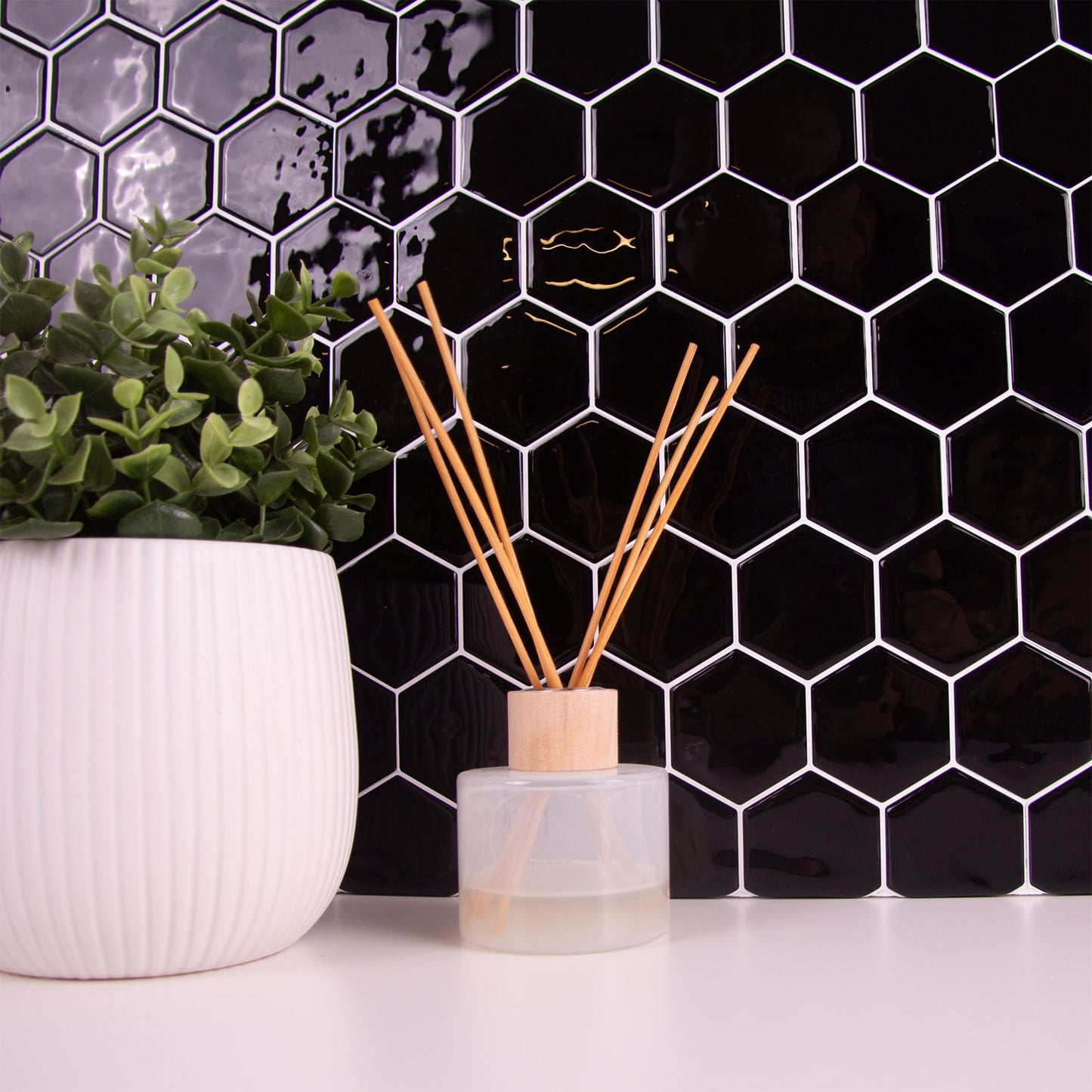 Sort peel and stick flise (onyx hive) i bryggers med hvid bordplade.